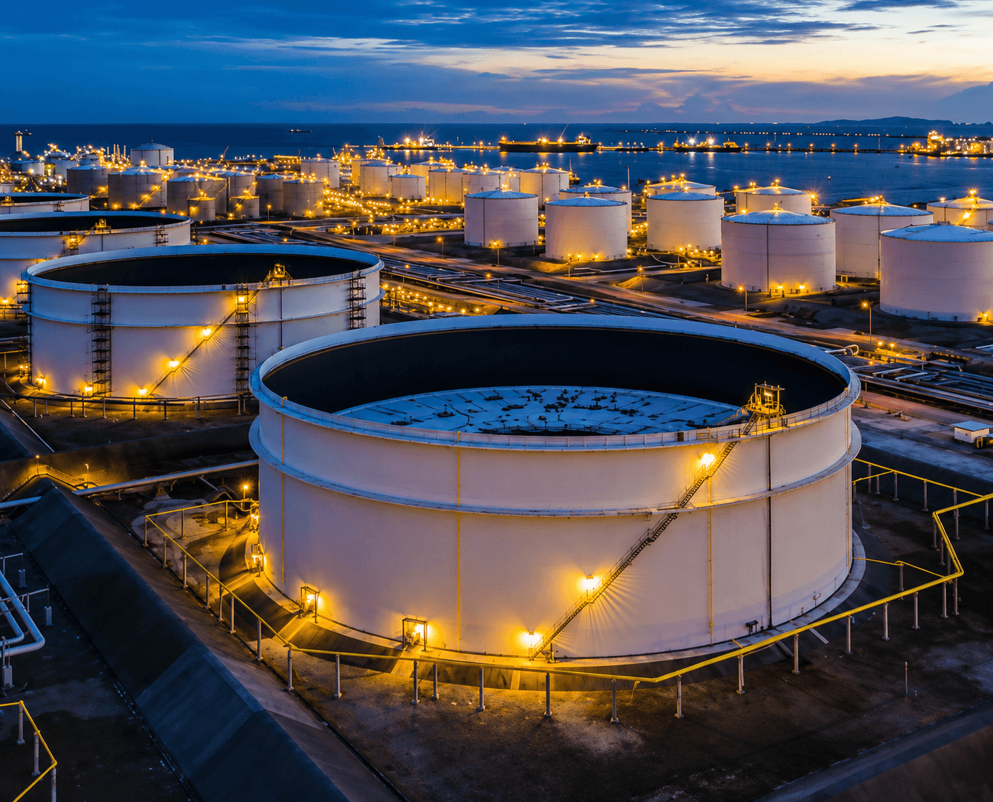 Coastal petroleum storage terminal illuminated at dusk